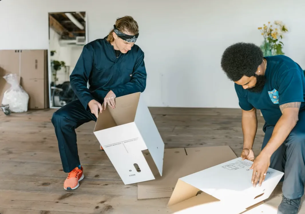 Two people assembling moving boxes