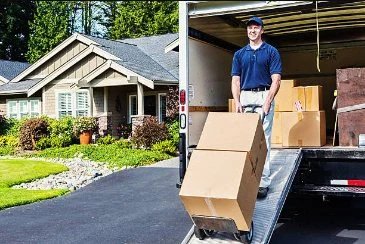Mover bringing a boxed item down a moving-truck ramp