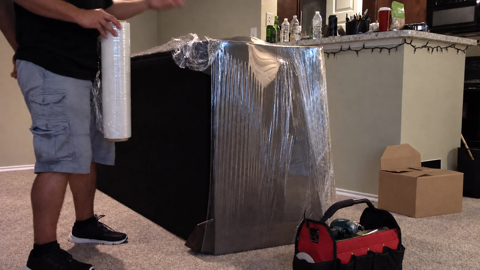 A mover applying protective stretch wrap to furniture